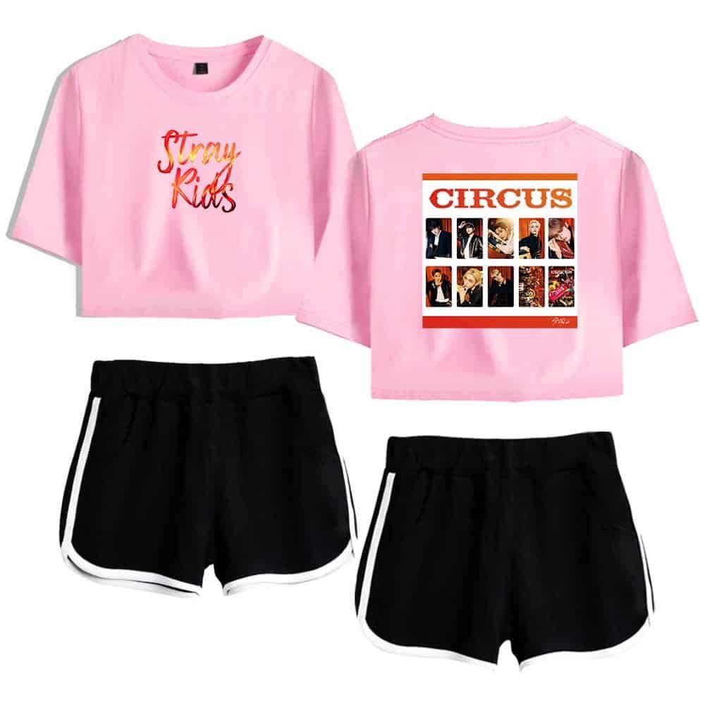 Pink crop top with "Stray Kids" text and group photo print on the back, black athletic shorts with white trim, K-pop merchandise, casual fan apparel, BTS-inspired style.